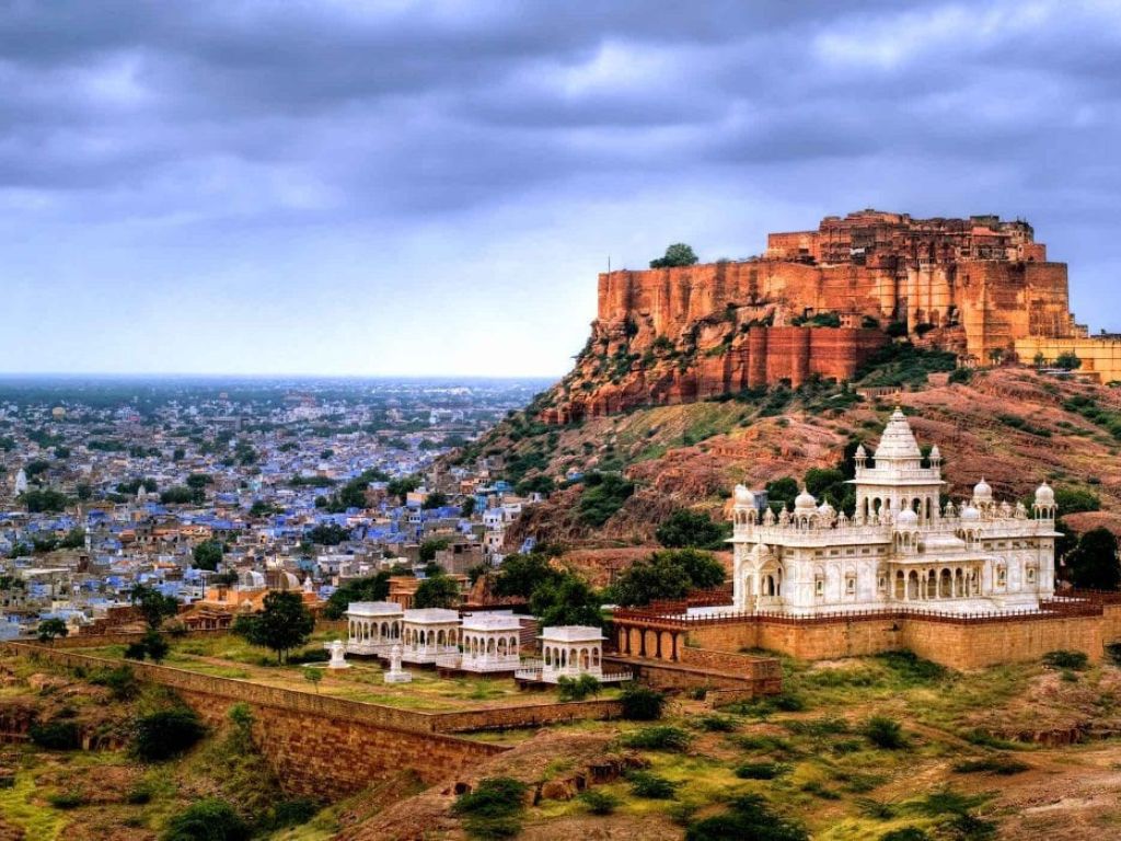 Aerial view of the Mehrangarh Fort in Jodhpur, Rajasthan, India, surrounded by blue-painted buildings, showcasing the city's iconic architecture and vibrant culture."